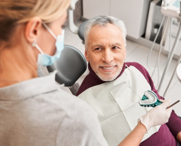 Man with denture smiling in dental treatment chair
