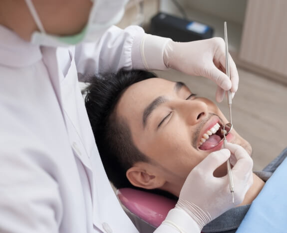 Man receiving dental checkup and teeth cleaning