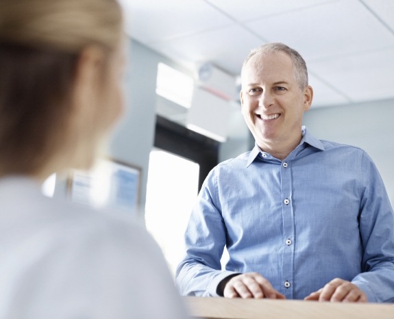 Man discussing the cost of dental emergencies with dentistry team member