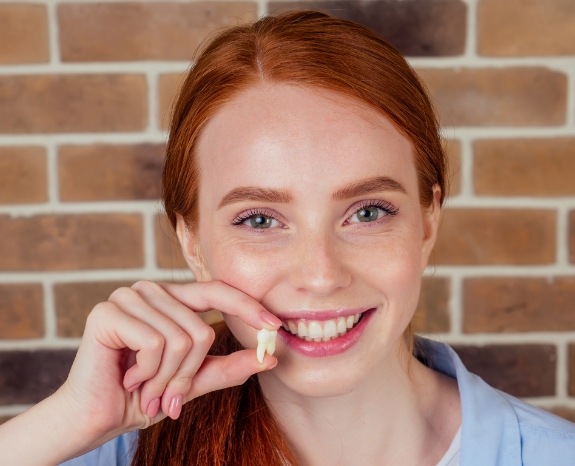 Woman holding a tooth after extractions