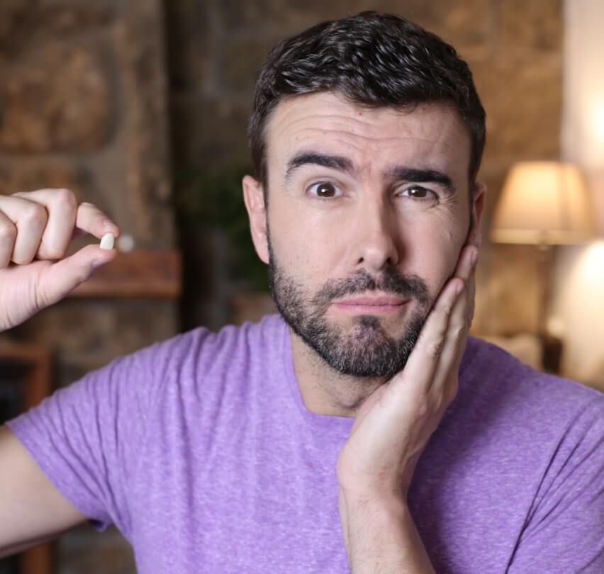 Man holding up knocked out tooth before replacing teeth