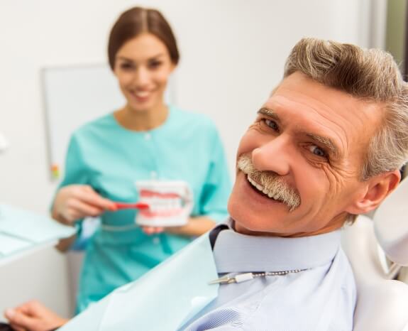 Smiling man with dentures in dental treatment