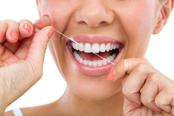 person spring cleaning their smile by flossing their teeth